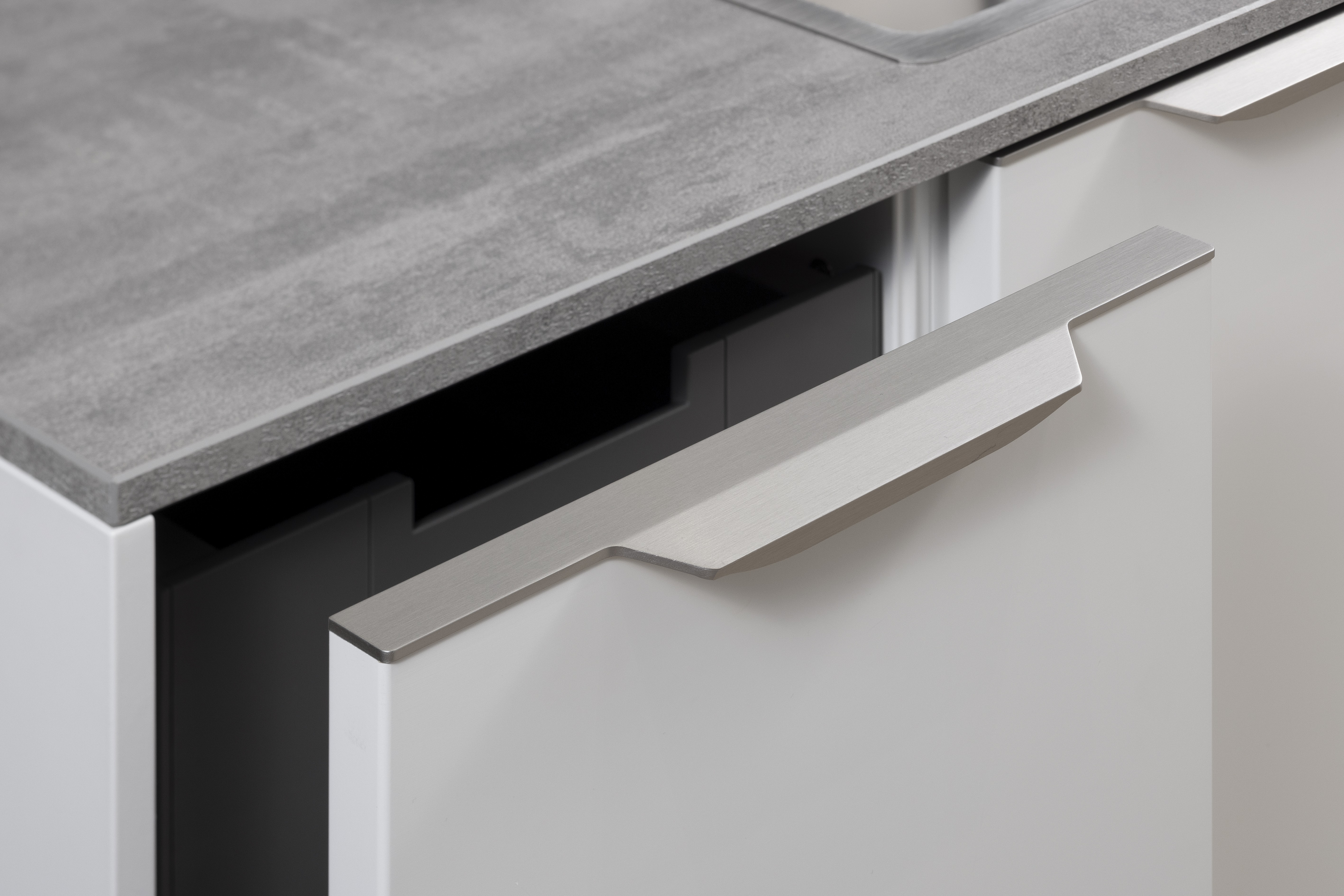 APL: Beton NP 12 mm Front: SoftLack Weiß softmatt Front: dunkles Holz NB Sepia Korpus: Weiß Griff: PTO und Edelstahloptik Geräte: Siemens, Kochfeld mit Abzug elica Armatur: Nobili Spüle: Franke    Features: Appartementküche, 90er Höhe, Materialkombi Weiß matt und dunkle Holzoptik mit Syncronpore (Oberflächenhaptik), Arbeitsplatz, Einbauschränke mit Sitzbank, Backofen in gedrehtem Schrankelement (Optik) somit kein Backofen in Küche sichtbar.