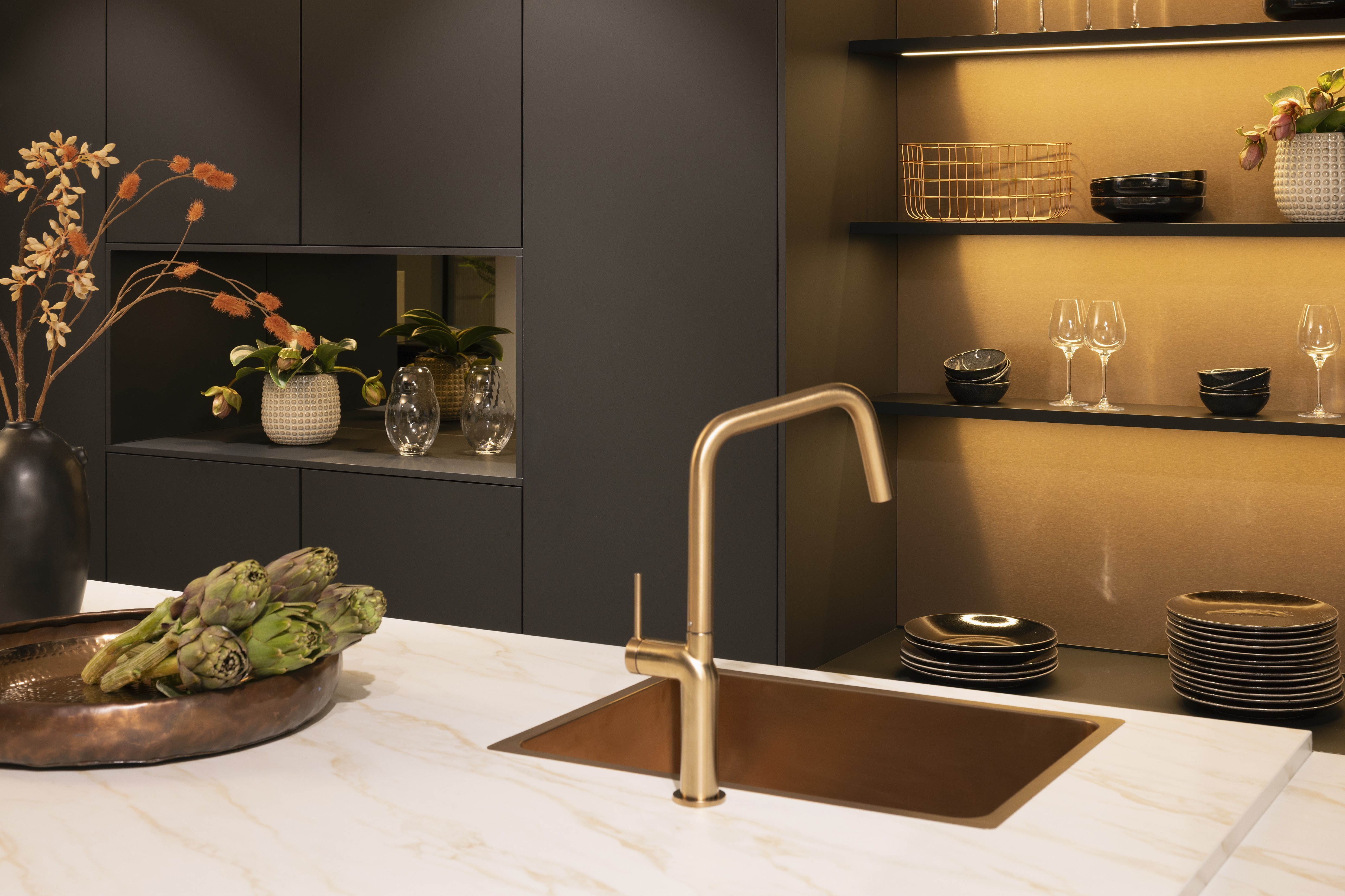 APL: 324 Marmor Carrara Bronze NB Korpus: 127 Schwarz Front: 496 Senso Lack Schwarz Premium matt Griff: Bronze Metallic (Line N) Geräte: Bosch Armatur: Gessi  Spüle: Rodi  Features: Neue Front in Trendfarbe Schwarz matt, Nischenelement mit Spielerückwand Farbe Bronze, beleuchtete Griffleiste, Push to open, neuer Schubkasten, Korpusfarbe schwarz, neues Nischendekor Bronze Glas, Trendfarbe Bronze (Eurocucina Milano), APL in Marmoroptik, Spülbecken und Armatur in Bronze, beleuchtete Regalleisten,Vorratsschrank