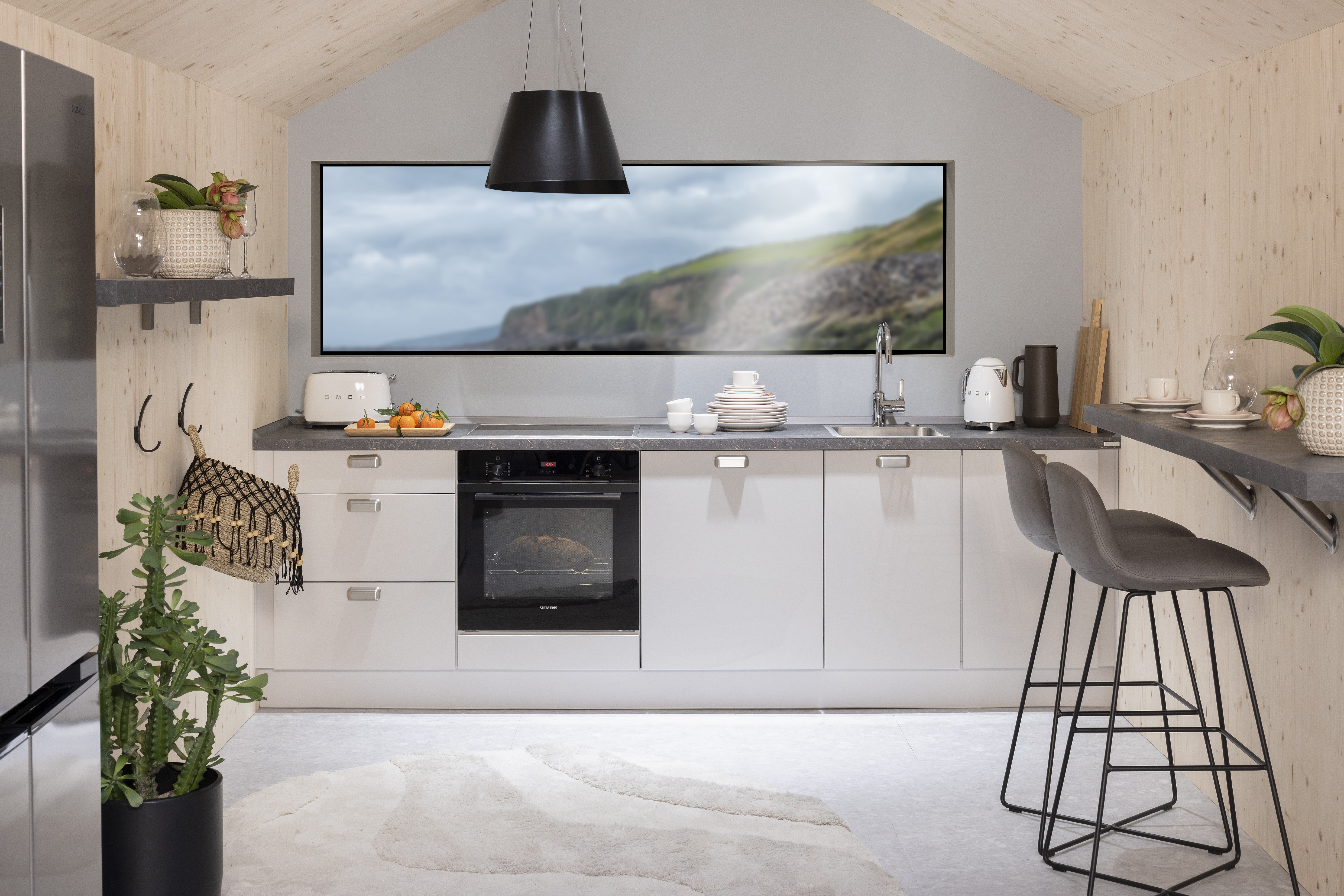 APL: 350 Granit Bronze geflammt NB Korpus: 070 Seidengrau Front: 455 Lacklaminat, Seidengrau Hochglanz Griff: Griffmuschel Edelstahlfarbig Geräte: Siemens Armatur: Kludi Spüle: Rodi  Features: Tiny House, Dachschräge, Einsteigerküche, Thekenlösung, Deckenhaube, neue Griffmuschel