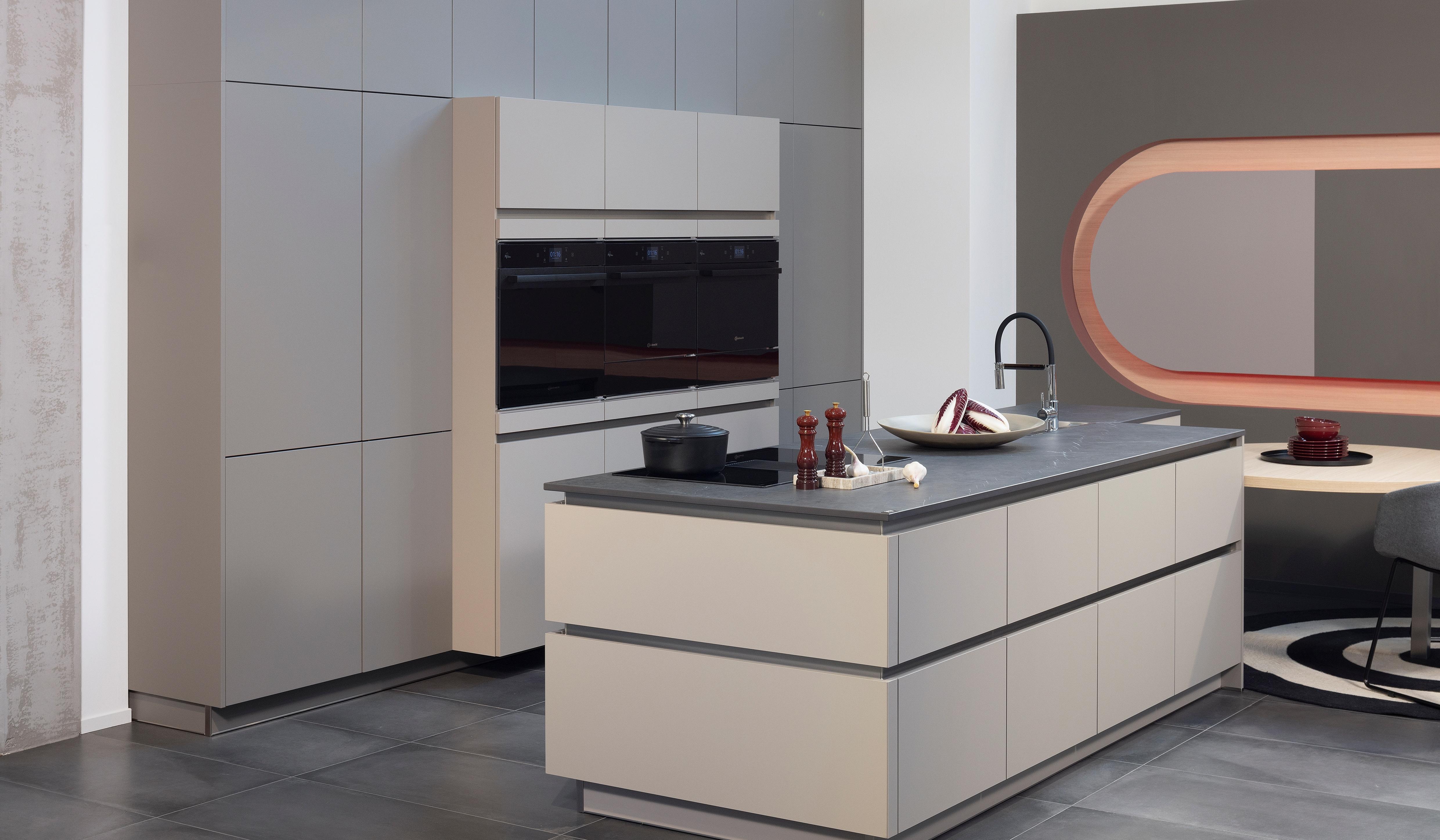 APL:Keramik Front: FEEL Farbe Basalt Front: FEEL FArbe Taupe Korpus: Graphit Griff: Grifflos Griffleiste Edelstahl Geräte: Bauknecht Armatur: Franke Spüle: Franke  Features: Keramik-APL, architektonisch stringente Planung, exakte Linienführung, Hochschränke teil eingekoffert, erzeugt verschiedene Tiefenwirkungen, Backöfen.