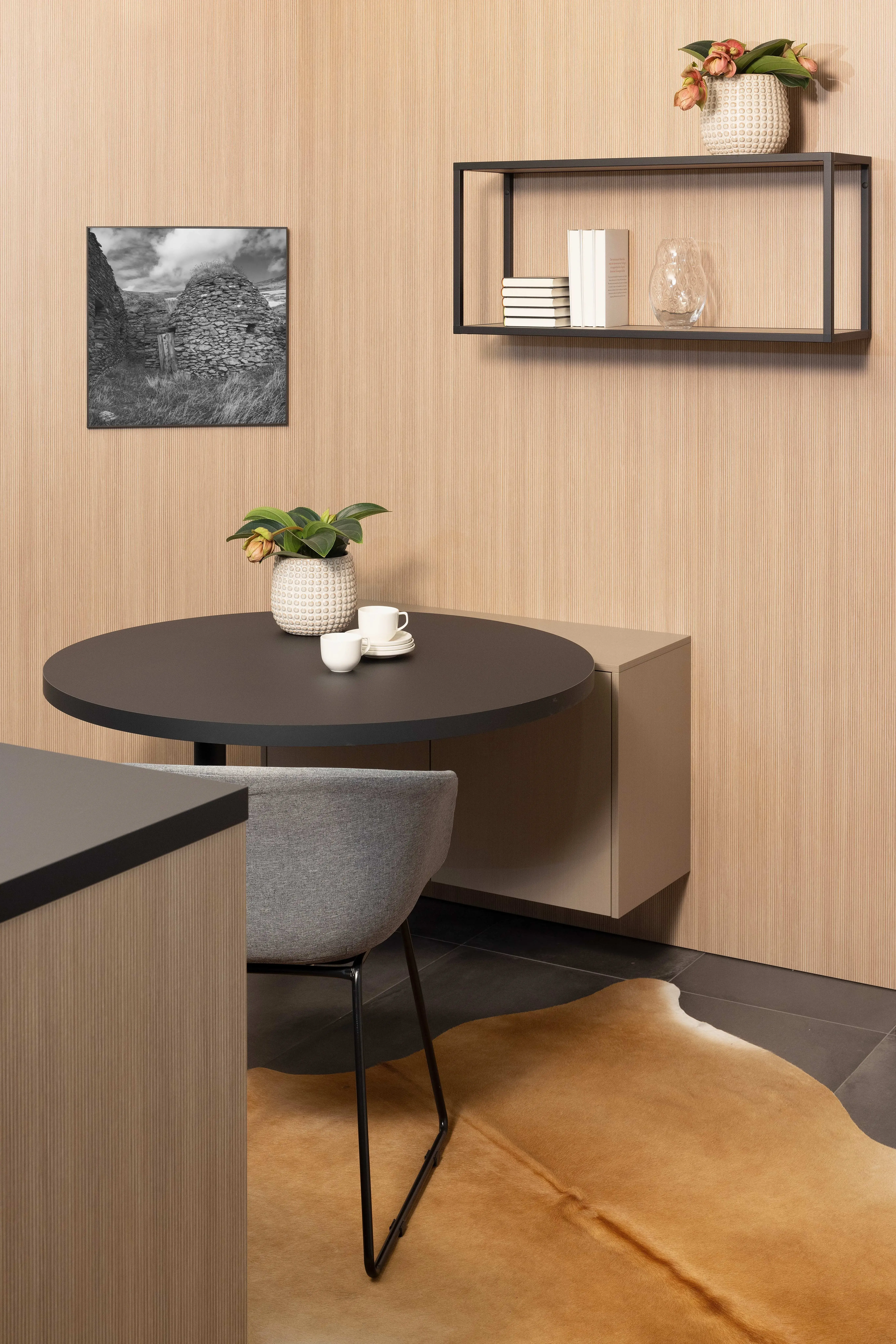 APL: Samtschwarz Front: Line Eiche liniert Front: INOX Light brushed Korpus: Graphit Griff: Grifflos Schwarz Geräte: Constructa Armatur: Franke Spüle: Franke  Features: eine der ersten Küchenfronten in neuer Farbe (Walze von damals), Nischenverkleidung Eiche liniert, Samtschwarze APL, Living (kleiner Sitzplatz mit Regal), Materialmix, Korpus in Graphit.